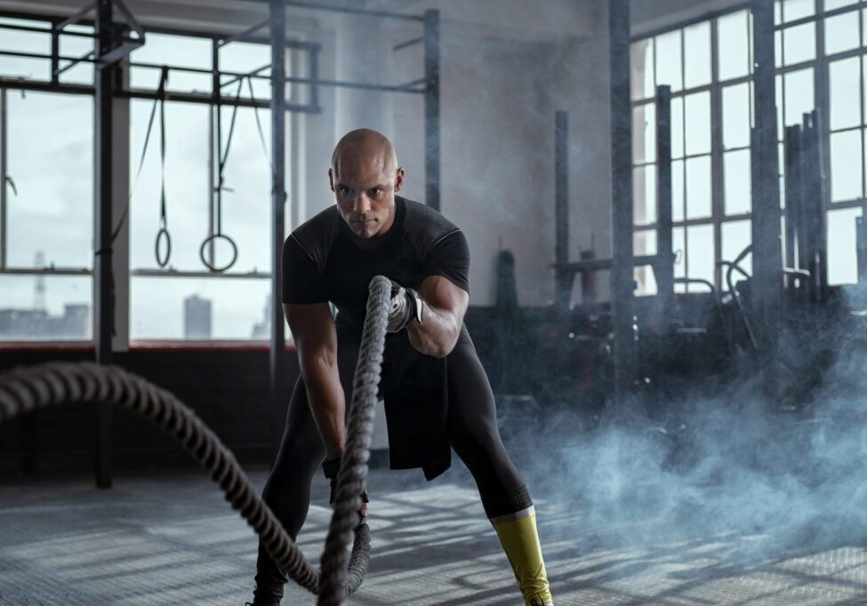 Bald,Athlete,Doing,Battle,Rope,Exercise,At,Crossfit,Gym.,Concentrated